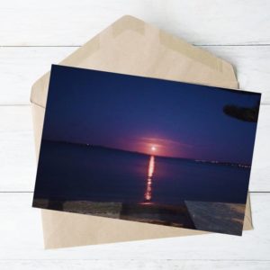 Deep blue sky and moon rising on eastern beach Auckland. calm