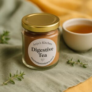 A glass jar of 'Digestive Tea' herbal blend with visible fennel and cumin seeds, styled alongside a steaming cup of tea and earthy props, promoting gut health